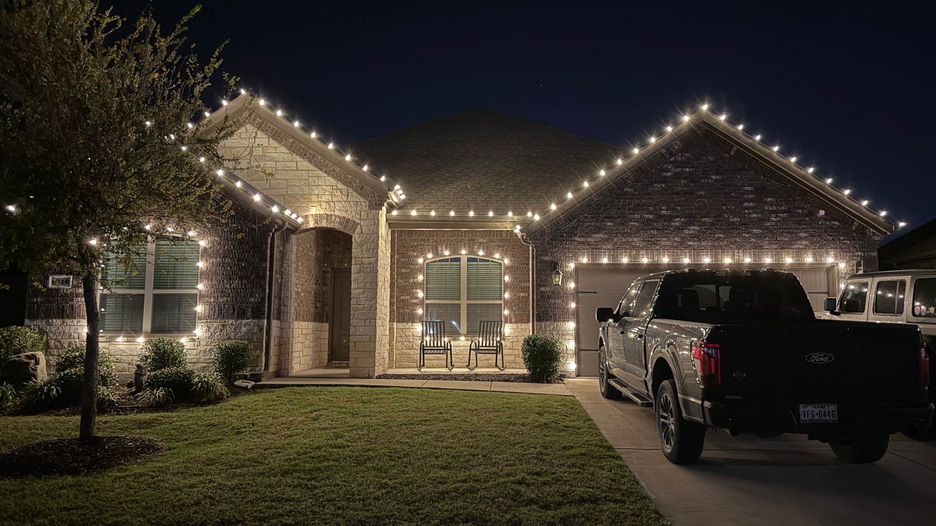 Classic warm white LED roofline lighting on a brick home at night